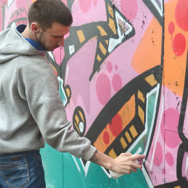 Un Jeune Homme Dans Un Sweat Gris à Capuche Peint Graffiti