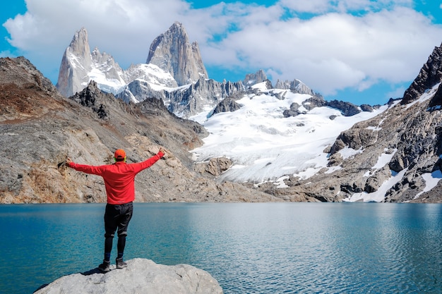 Jeune homme debout à bras ouverts et regardant le monte fitz roy et la laguna de los tres happy