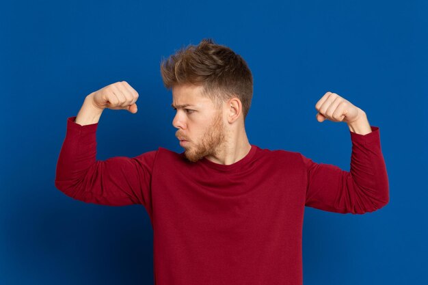 Un jeune homme debout sur un fond bleu