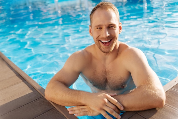 Jeune homme debout près de la piscine s'amuser