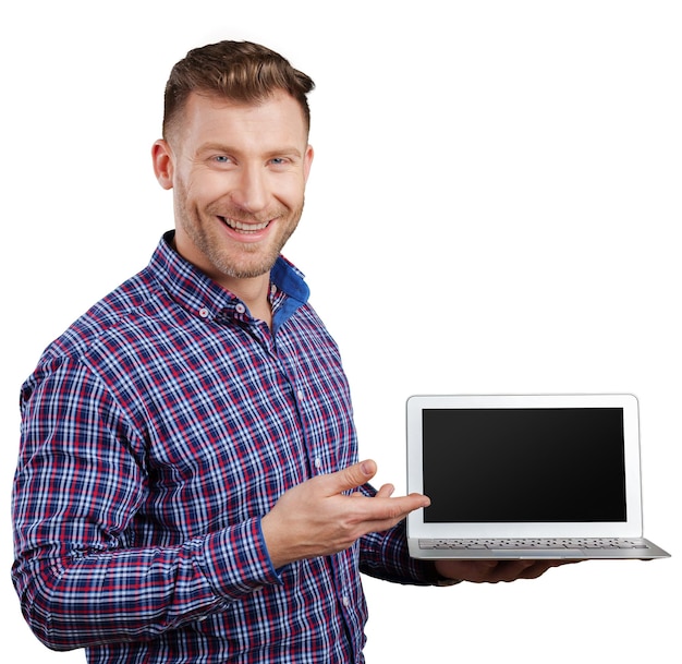 Jeune homme debout tenant un ordinateur portable travaillant