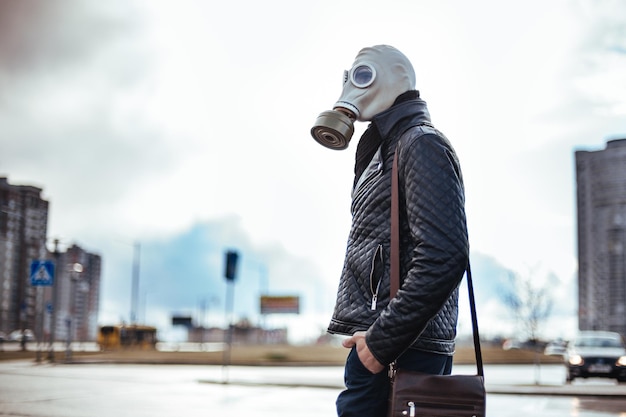 Jeune homme décontracté dans un masque à gaz dans une rue de la ville