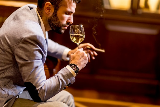 Jeune homme, dégustation, vin blanc, et, fumer, cigare