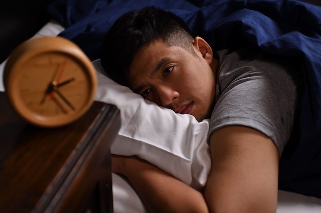 Photo un jeune homme déprimé souffrant d'insomnie au lit