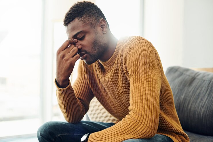 Photo un jeune homme détourne le regard alors qu'il est assis sur le canapé