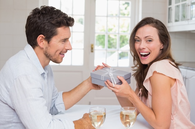 Photo jeune homme donnant une boîte-cadeau de femme heureuse