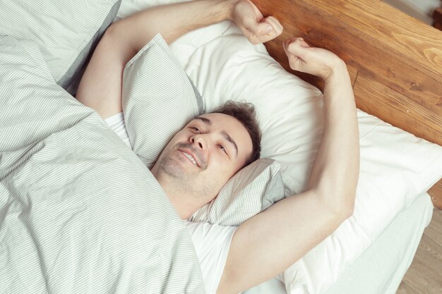 Jeune homme, dormir, lit, dans, chambre à coucher