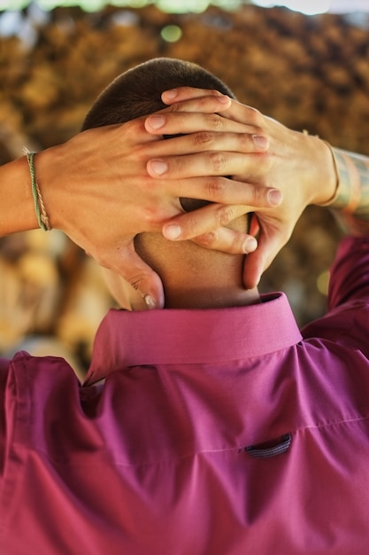 Photo jeune homme de dos, les bras croisés derrière la tête, les mains dans le château