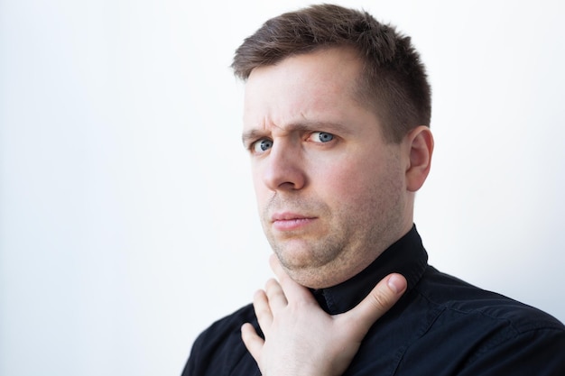 Jeune homme avec un double menton en t-shirt noir Problèmes avec une bonne nutrition