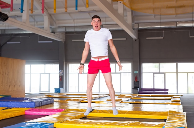 Jeune homme drôle de trampoline dans le parc à mouches.