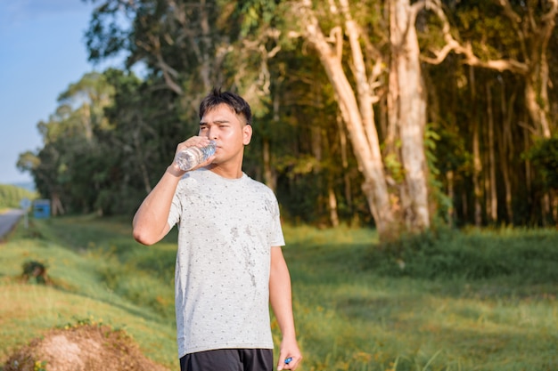 Jeune homme de l&#39;eau potable avant de travailler sur l&#39;exercice