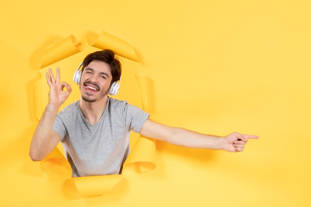 jeune homme écoutant de la musique dans des écouteurs sur fond jaune échographie audio sonore