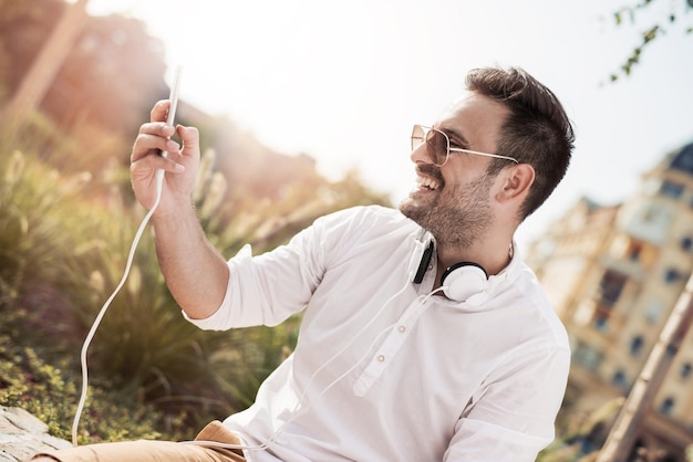 Jeune homme écoutant de la musique sur un téléphone intelligent