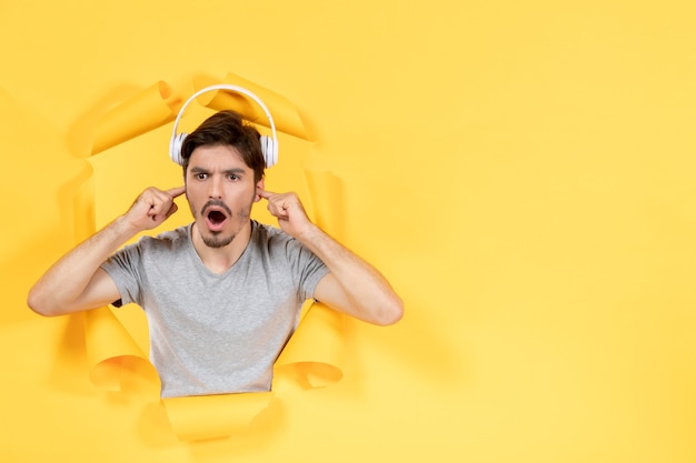 jeune homme avec des écouteurs sur fond jaune musique ultrasonore audio