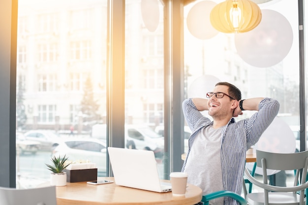 Jeune homme élégant au café