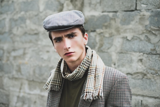 Jeune homme élégant contre un mur gris Style ancien rétro et vintage