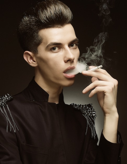 Jeune homme élégant, fumant une cigarette