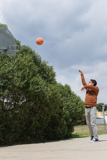 Photo le jeune homme élégant joue avec la boule dehors