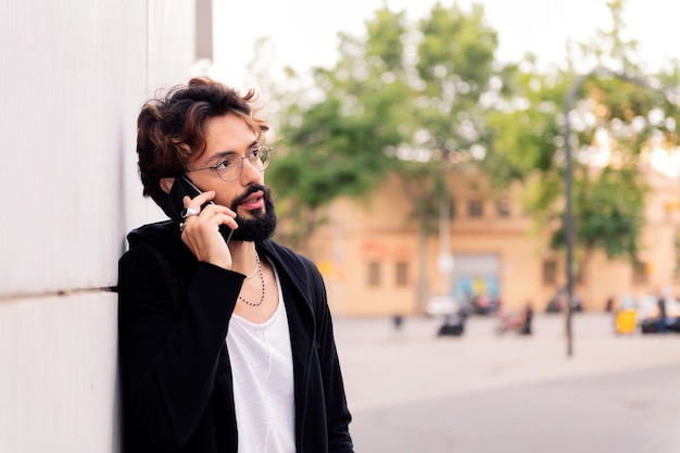 Jeune homme élégant parlant au téléphone portable