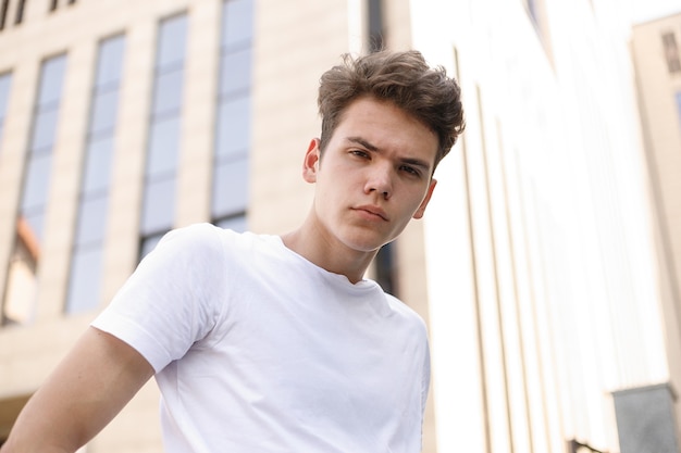 Jeune homme élégant posant avec un t-shirt blanc à la mode