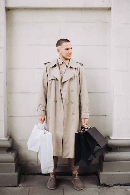Un jeune homme élégant avec des sacs après des achats réussis le vendredi noir