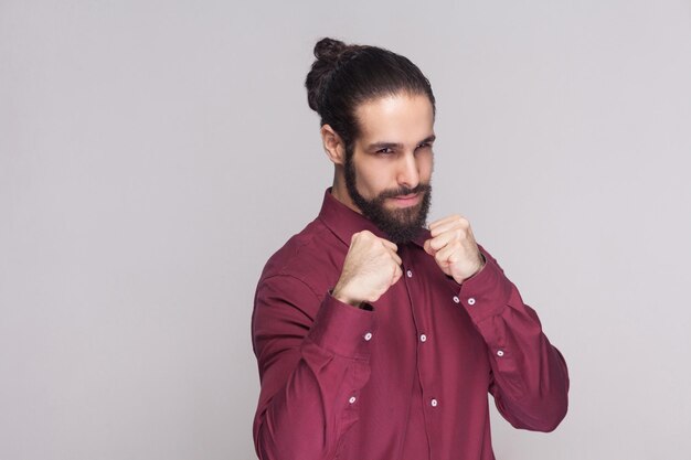 Jeune homme émotif avec la barbe sur le fond gris