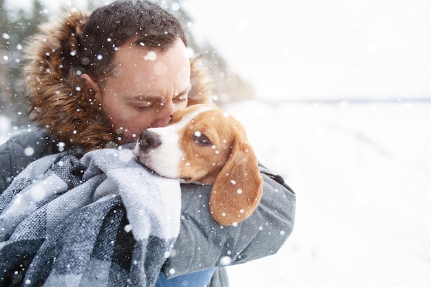 Un jeune homme a enveloppé son meilleur chien Beagle dans une couverture chaude pour le réchauffer