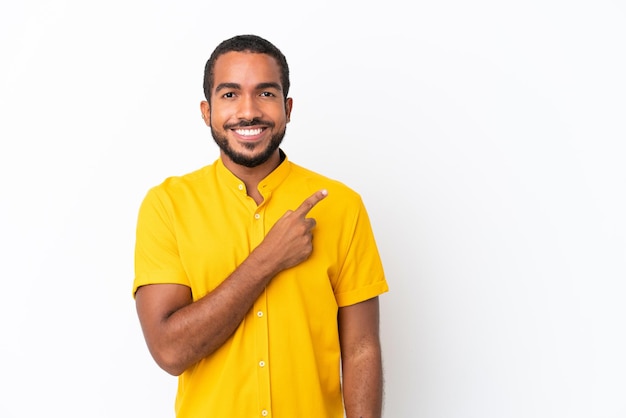 Jeune homme équatorien isolé sur fond blanc pointant vers le côté pour présenter un produit