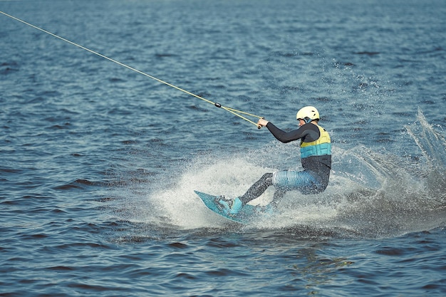 Jeune homme équitation wakeboard sur un lac d'été.