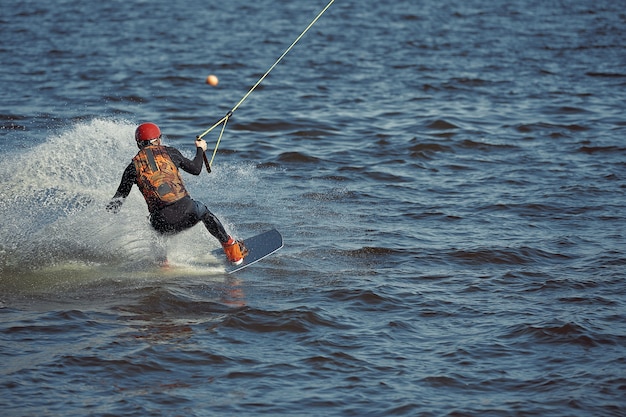 Jeune homme équitation wakeboard sur un lac d'été