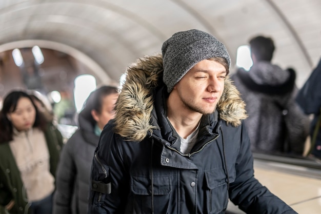 Jeune homme sur l'escalator dans le métro b