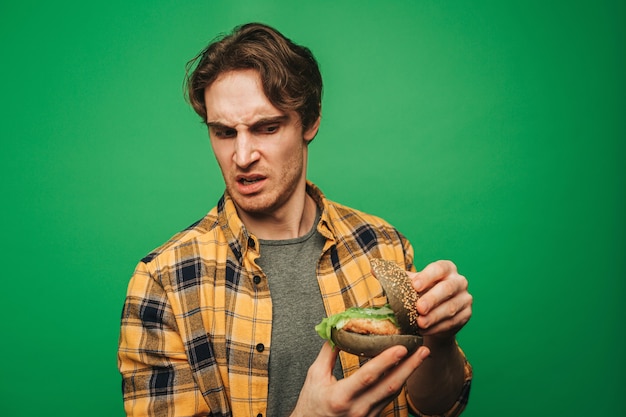 Un jeune homme est déçu à cause d'un hamburger gâté