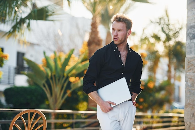 Jeune homme est à l'extérieur pendant la journée ensoleillée Concept de vacances