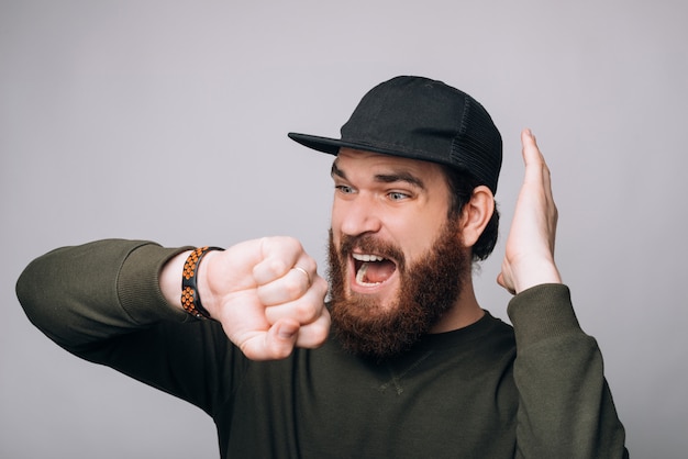 Le jeune homme est stressé quand il voit l'heure sur sa montre-bracelet.