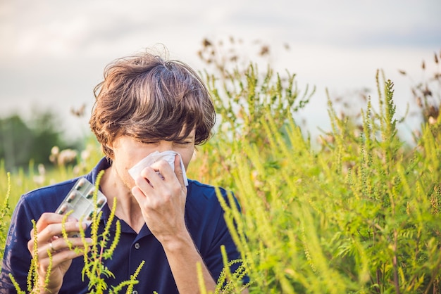 Photo un jeune homme éternue à cause d'une allergie à l'ambroisie