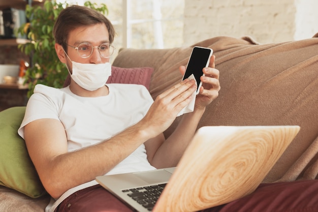 Jeune homme étudiant à la maison lors de cours en ligne pour désinfecteur, infirmière, services médicaux.