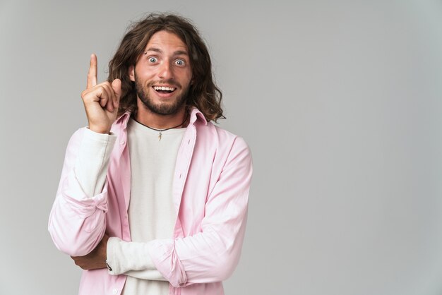 Jeune homme excité portant une tenue décontractée debout isolé sur gris