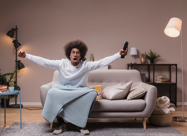 Jeune homme excité en regardant le football