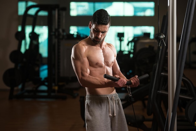 Jeune homme exerçant des biceps dans la salle de gym