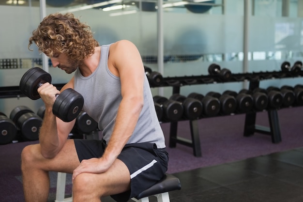 Jeune homme exerçant avec haltère dans la salle de gym