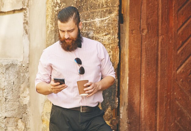 Jeune homme à l'extérieur en regardant son téléphone portable