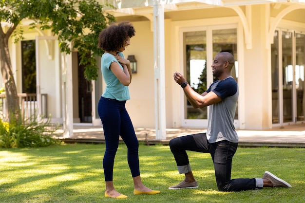 Jeune homme faisant une demande en mariage dans le jardin