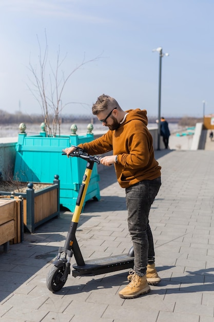 Jeune homme faisant du scooter électrique en contexte urbain concept de transport et de style de vie moderne