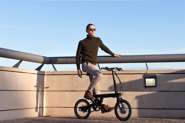 Jeune homme faisant du vélo électrique comme moyen de transport urbain durable pour éviter la pollution dans la ville