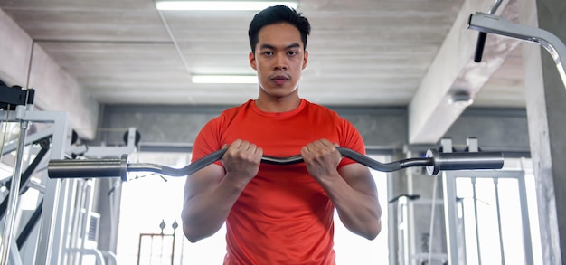 Photo jeune homme faisant de l'exercice dans la salle de gym soulever des poids améliorant la santé renforcer les muscles pour la force concept d'exercice