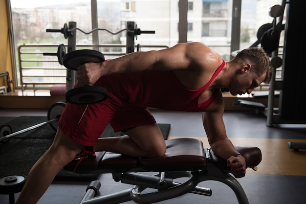 Jeune homme faisant de l'exercice pour les triceps avec des haltères