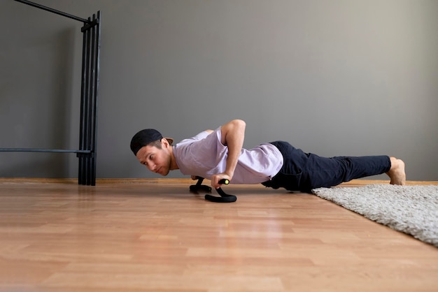 Un jeune homme faisant des exercices de fitness sur le sol à la maison