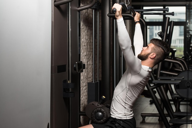 Jeune homme faisant des exercices de poids lourds pour le dos dans la salle de sport