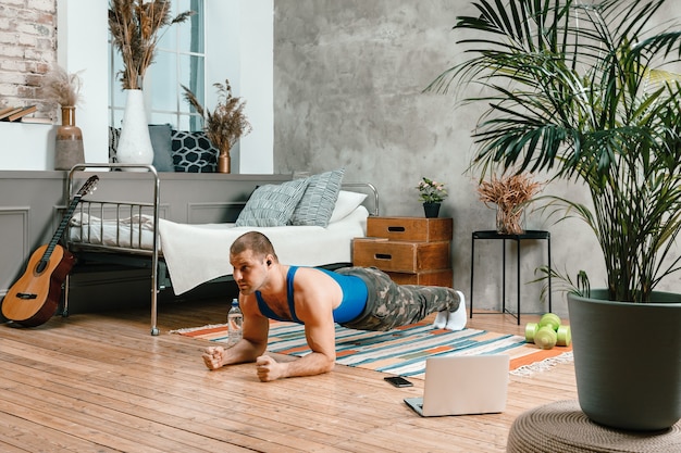 Photo le jeune homme fait du sport à la maison