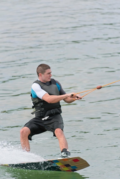 Un jeune homme fait du wakeboard.